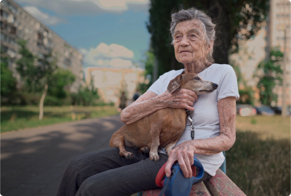 Leva med KOL, äldre kvinna sitter utomhus med en hund i famnen